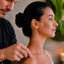 Man applying pants to a woman's neck and shoulders in a calm setting.