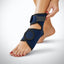 Navy blue ankle support brace being worn on a foot with a plain background