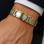 Close-up of a wrist wearing a silver and gold bracelet.