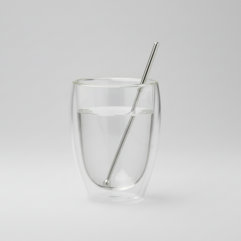 Clear glass with a Magnetic pencil  on a light gray background