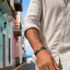 Person wearing a light-colored shirt with a colorful street in the background