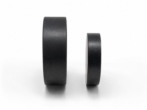 Two matte black circular magnet discs, one larger and one smaller, standing upright on a clean white background.