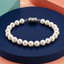 Pearl bracelet with a silver clasp on a blue and orange geometric background