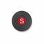A round black textured item, likely a coaster or small plaque, featuring a central red circular emblem with a white letter 'S'.
