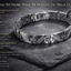 Silver magnetic bracelet on a dark stone surface with product details.