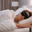 Woman sleeping in bed with the Premium magnetic eye mask on, in a bedroom setting.