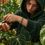 Joven regando plantas con pulsera de turquesa en primer plano